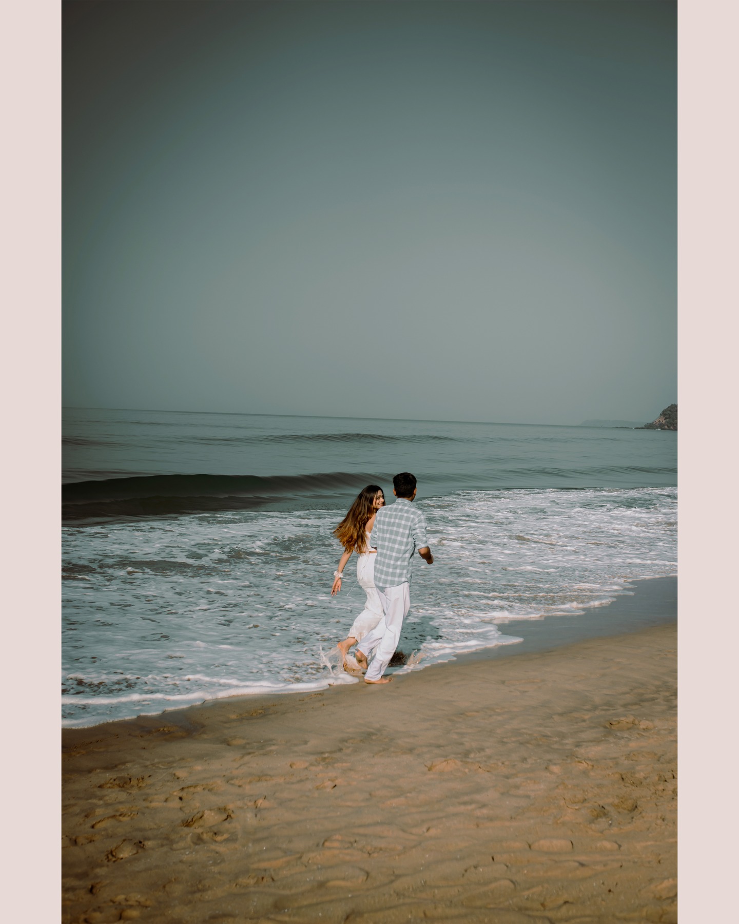 A couple walking along the sea during a BTS Film Studio shoot in Goa